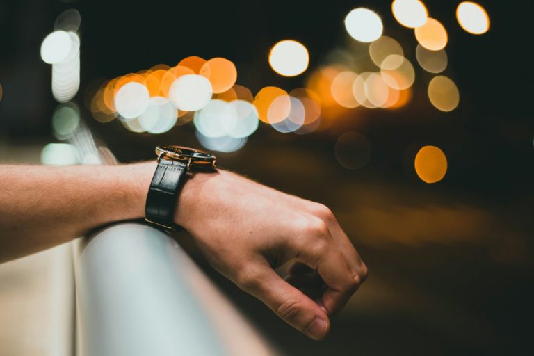 person wearing silver link bracelet watch